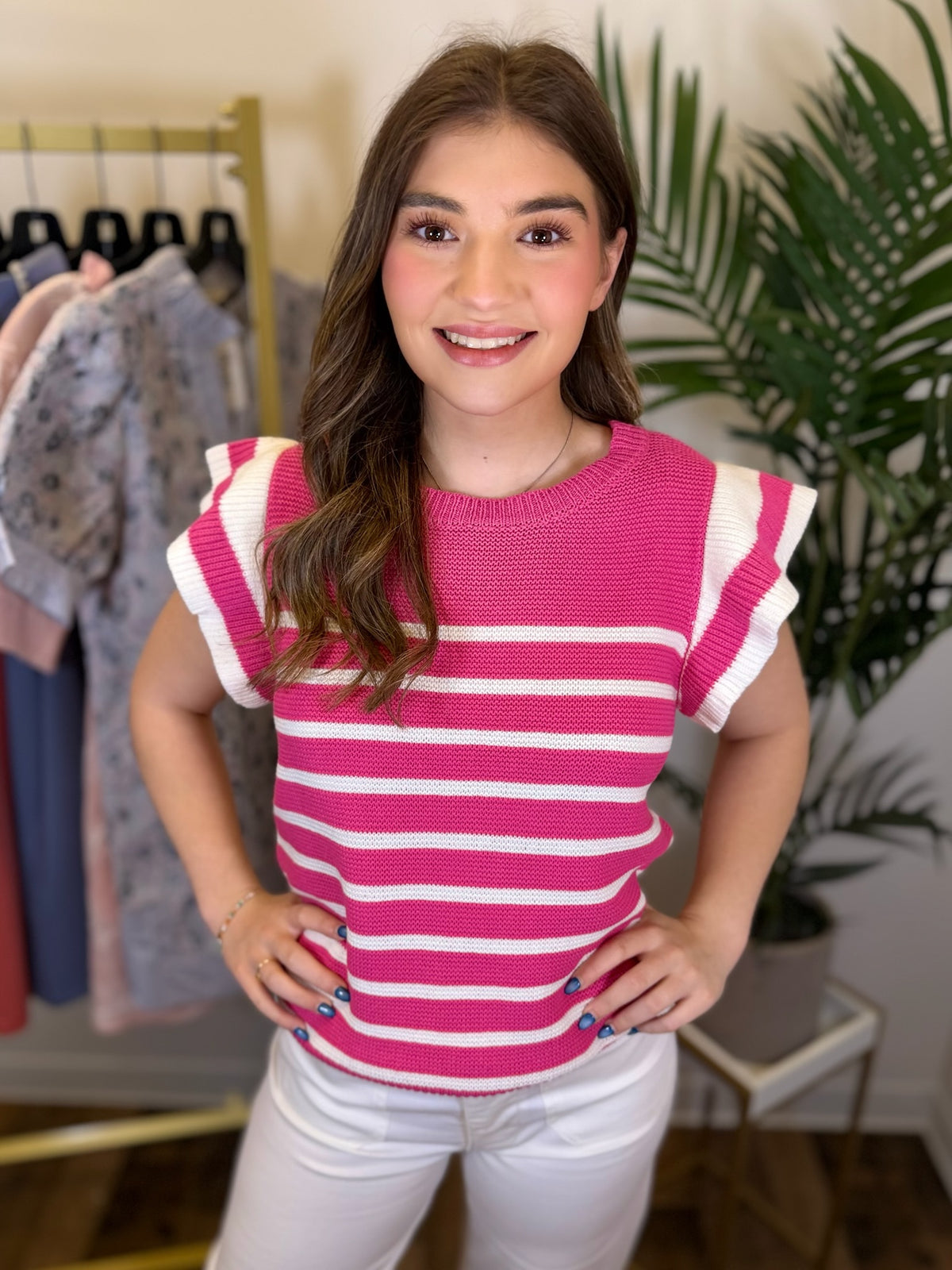 Woman wearing a pink and white striped shirt in a clothing store.