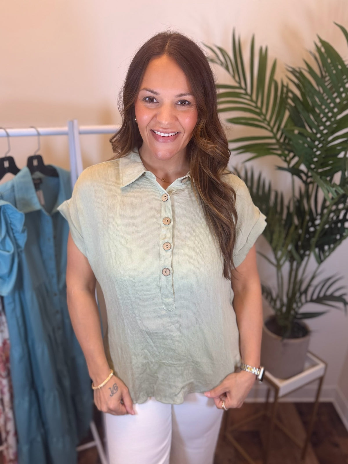 Woman wearing ribbed sage top with short sleeves and button details.