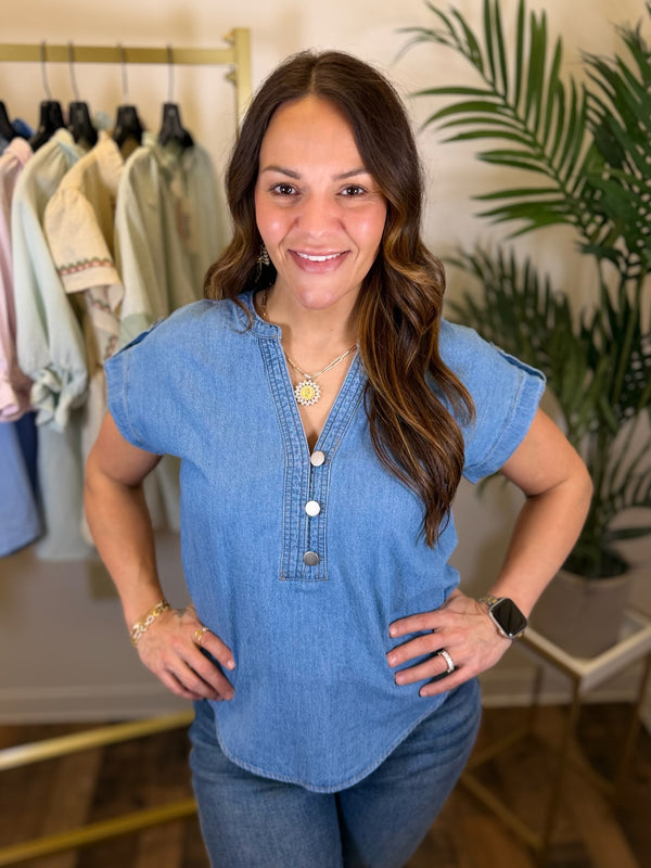 Woman wearing a blue denim top in a clothing store setting