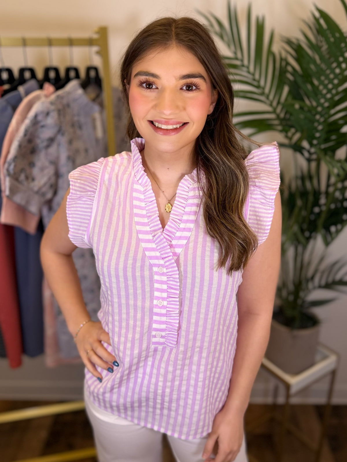 Woman wearing a purple and white striped shirt in a clothing store.