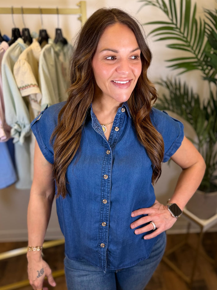 Woman wearing a blue denim shirt in a clothing store setting