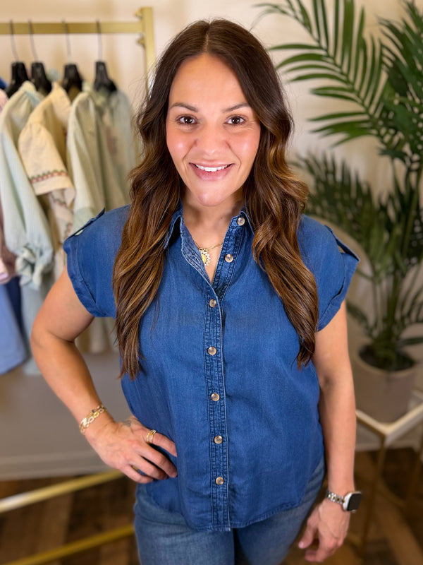 Woman wearing a blue denim shirt in a clothing store setting