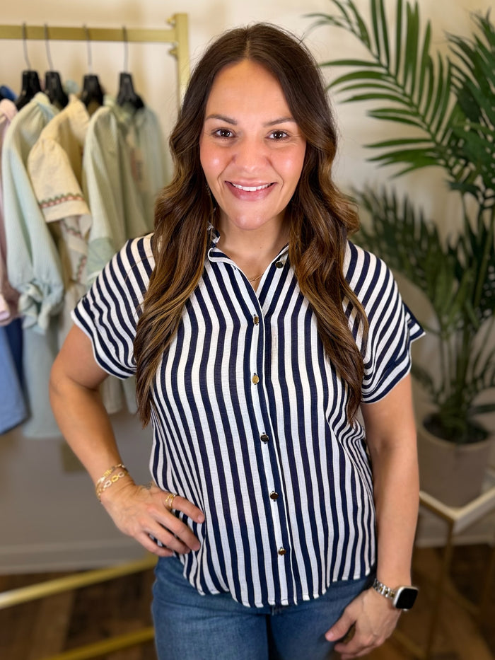 Woman wearing a navy and white striped shirt in a clothing store.