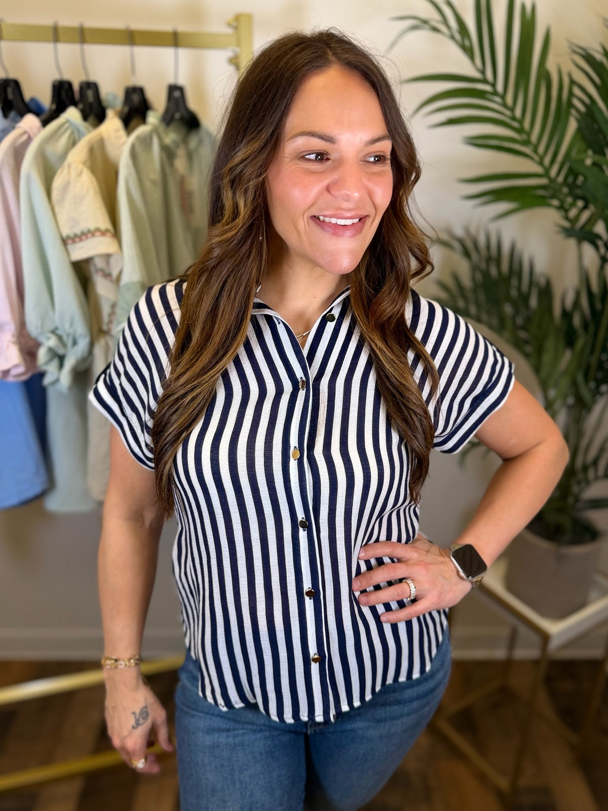 Woman wearing a navy and white striped shirt in a clothing store.
