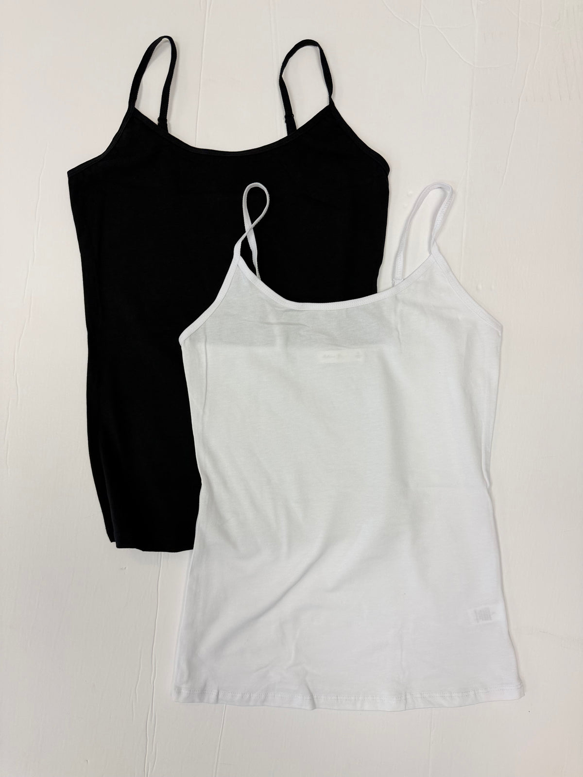 Black and white sleeveless tank tops on a white background.