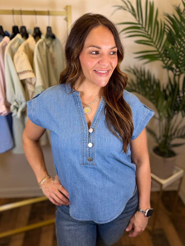 Woman wearing a blue denim shirt in a clothing store setting