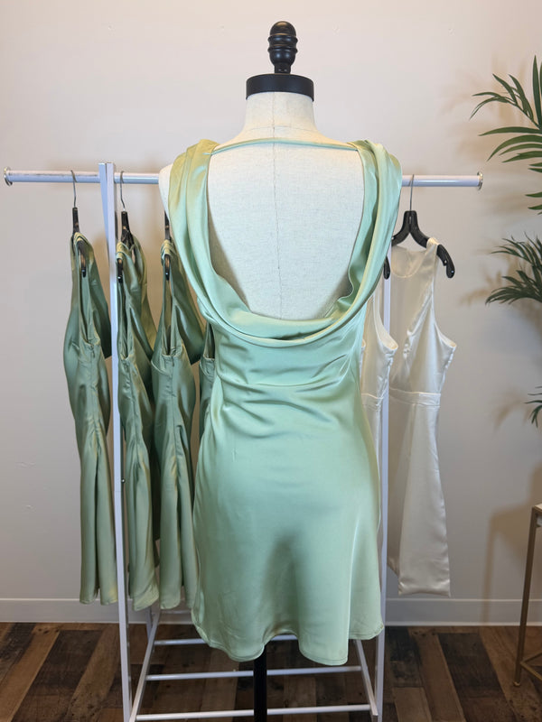 Mannequin wearing silky Sage mini dress showing open back with draped detail.