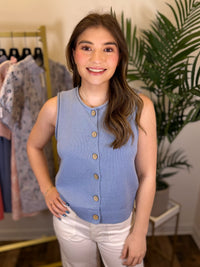 Woman wearing a blue sleeveless cardigan in a clothing store setting