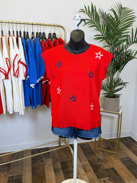Red top with star patterns on a mannequin in a clothing store setting.