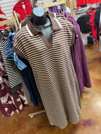 A brown and white horizontally striped short-sleeve polo dress displayed on a black mannequin torso in a retail clothing store. The dress features solid brown trim at the collar and sleeve cuffs.