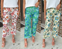 Three pairs of floral pants worn by a person, each with a different color scheme.